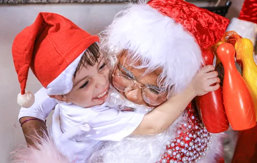 Criança feliz com a visita do Papai Noel