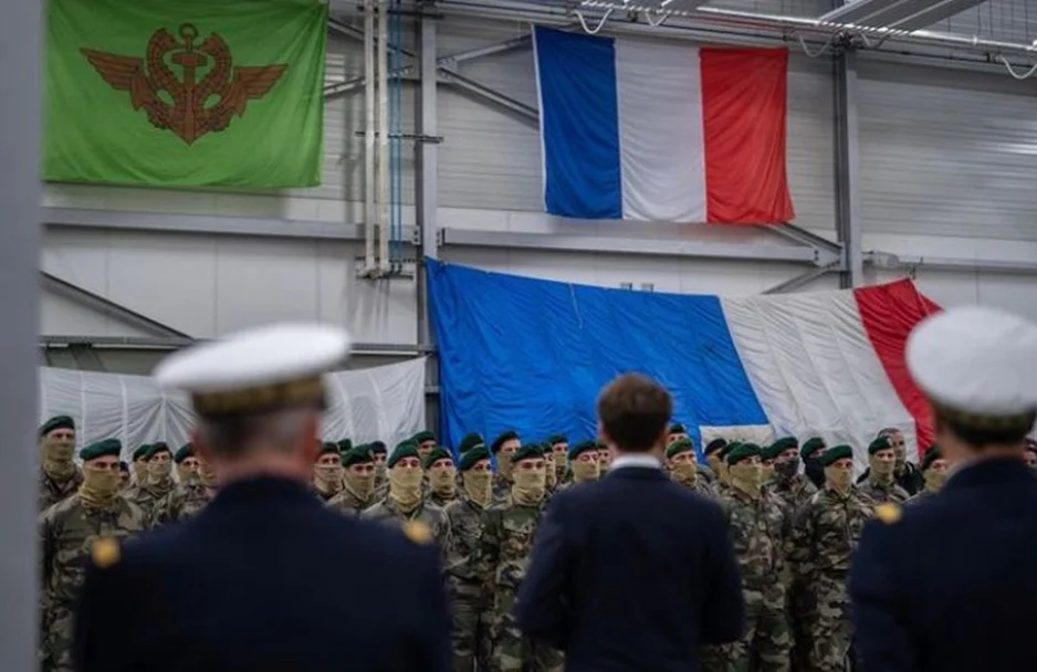 Presidente Emmanuel Macron em frente à bandeira da França