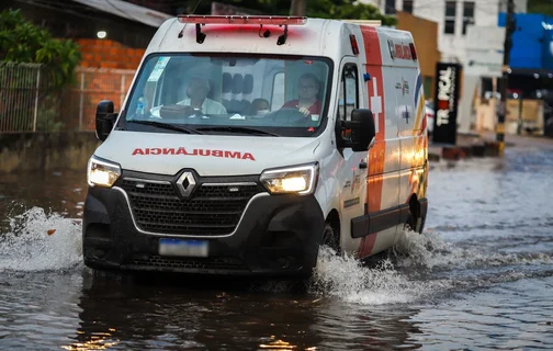 Ambulância transitando na via alagada