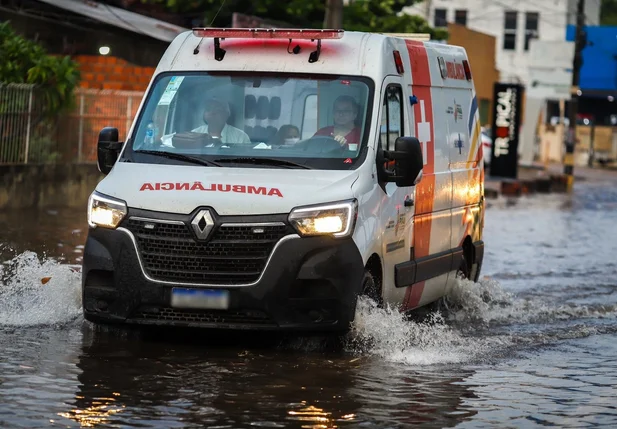 Ambulância transitando na via alagada