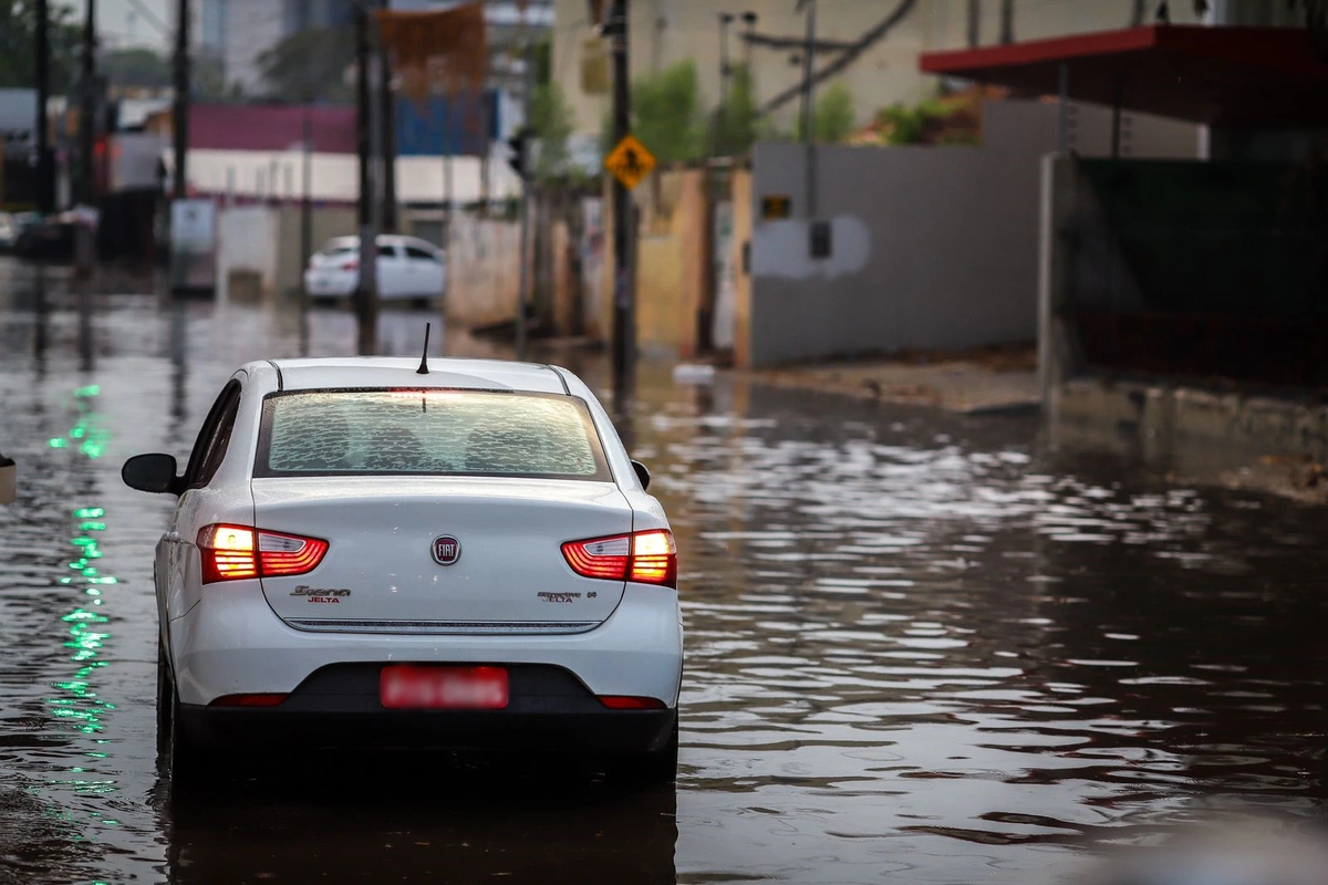 Carro andando em avenida alagada