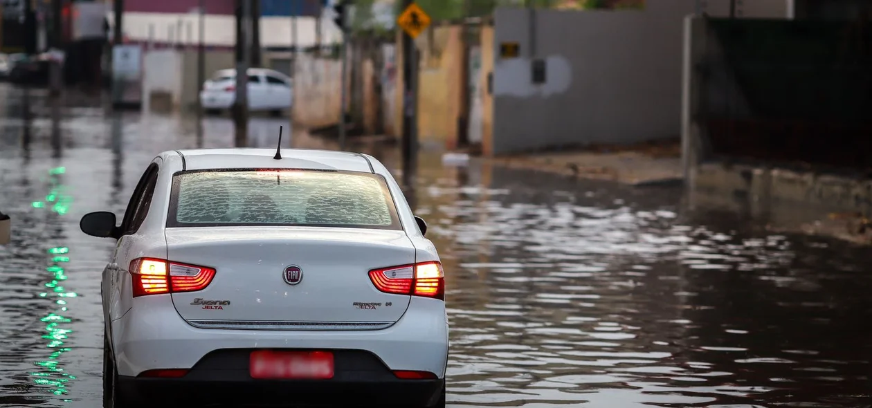 Carro andando em avenida alagada