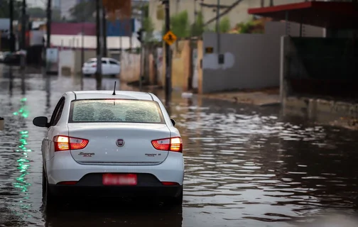 Carro andando em avenida alagada