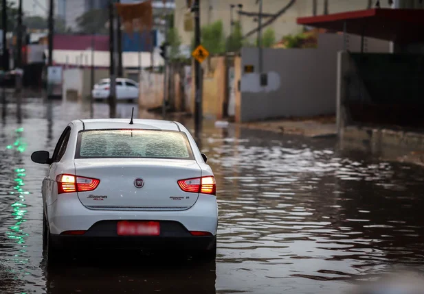 Carro andando em avenida alagada