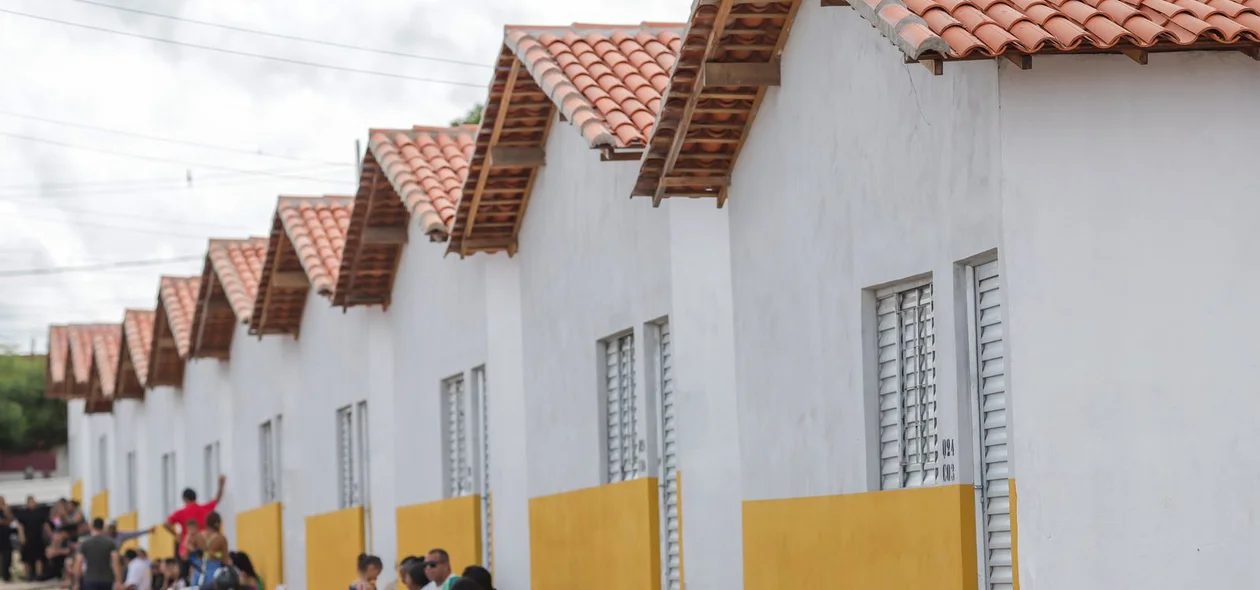 Famílias em frente às novas casas