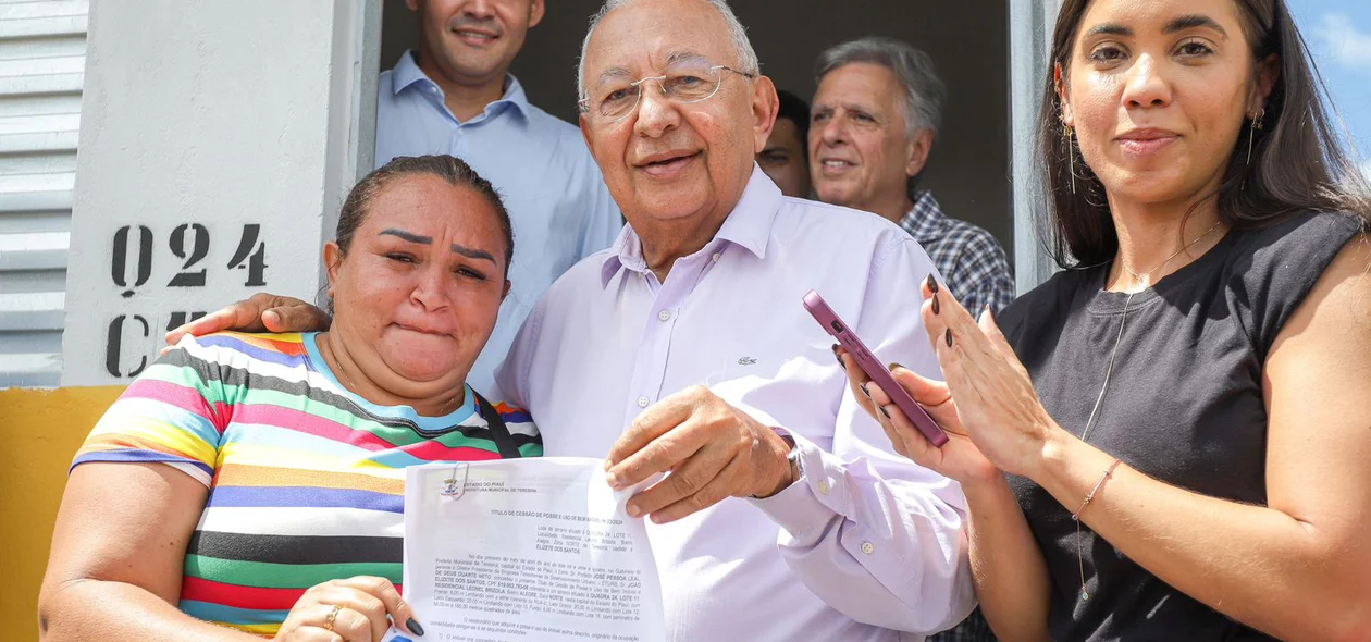 Prefeito Dr. Pessoa entregando documento de posse dos imóveis às famílias