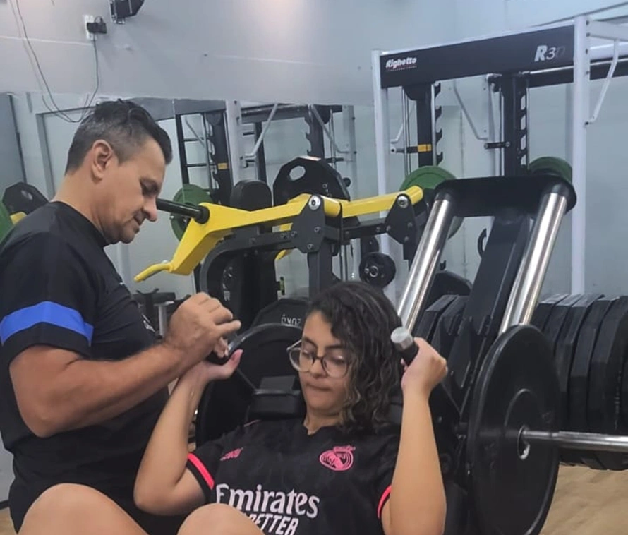 Professor Demóstenes Ribeiro com Maria Vitória, quanto mais cedo começar na musculação, melhor