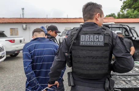 Delegado Charles condizindo um dos presos durante operação