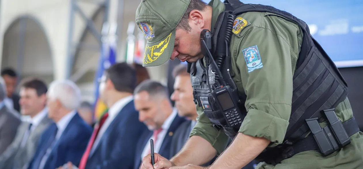 Comandante Geral assinando documento de adesão ao uso de câmeras corporais em policiais militares