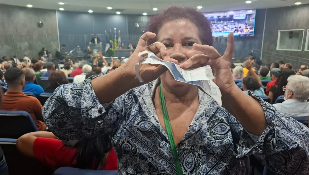 Rosimeire Gomes indignada rasgando sua conta de água