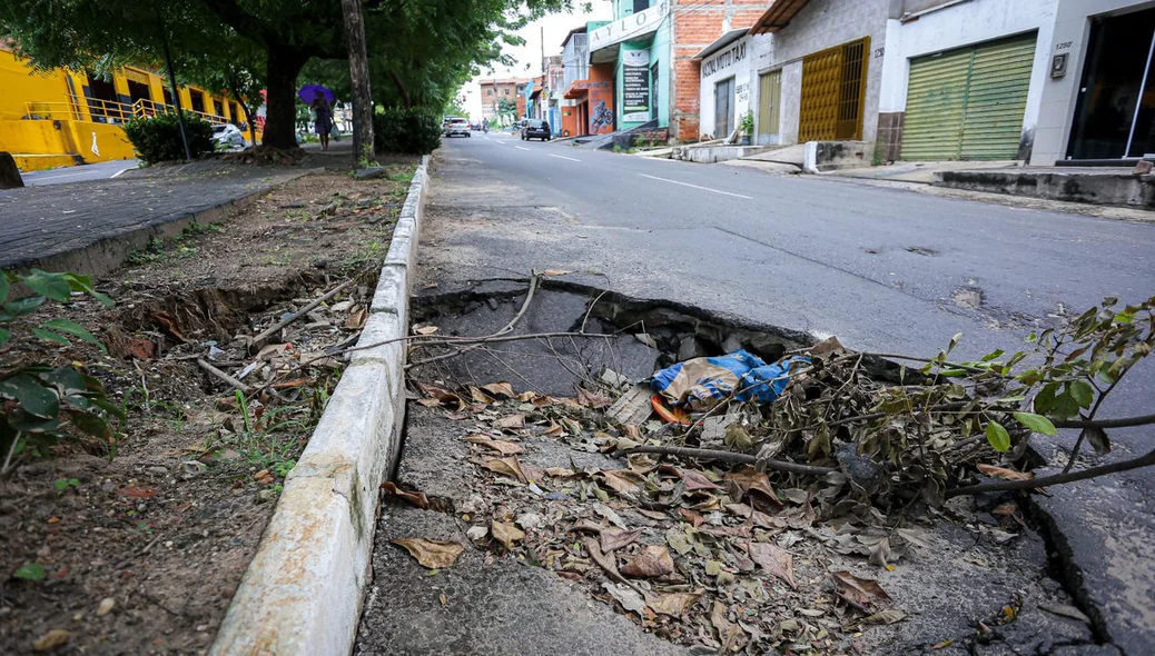 Resíduos acumulam em buraco na rua